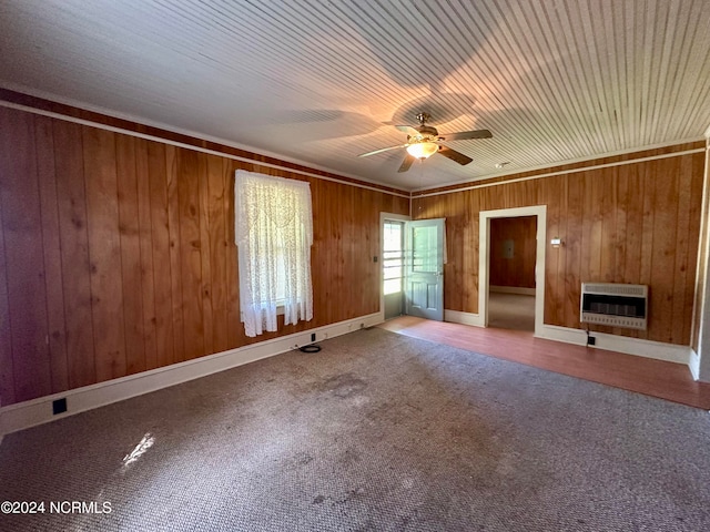 unfurnished bedroom with wood walls, a fireplace, crown molding, ceiling fan, and heating unit