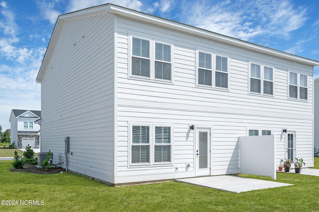 back of house featuring a lawn, a patio area, and central AC