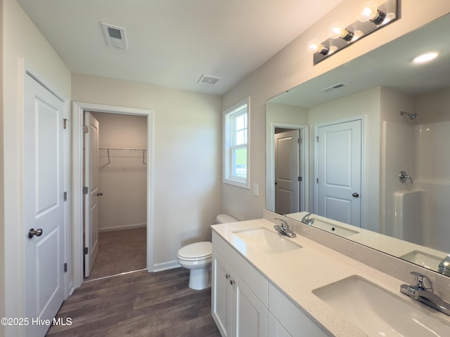 bathroom with toilet, visible vents, and a sink