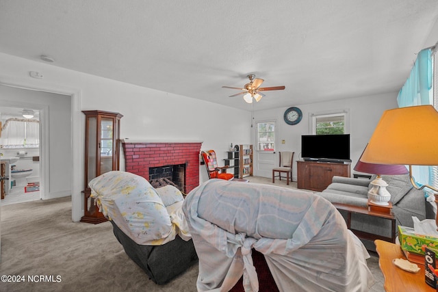 living room featuring light carpet, a textured ceiling, a brick fireplace, and ceiling fan