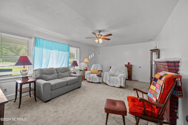 living room featuring a textured ceiling, ceiling fan, and carpet floors