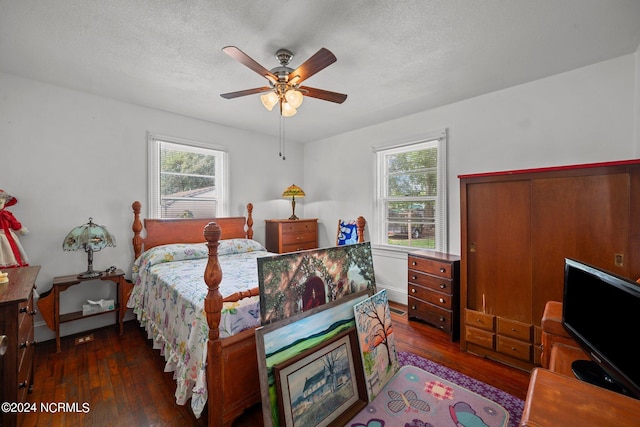 bedroom with a textured ceiling, ceiling fan, and dark hardwood / wood-style floors