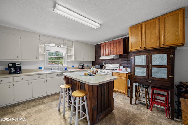 kitchen with a breakfast bar area, a kitchen island, gas range gas stove, and white cabinets