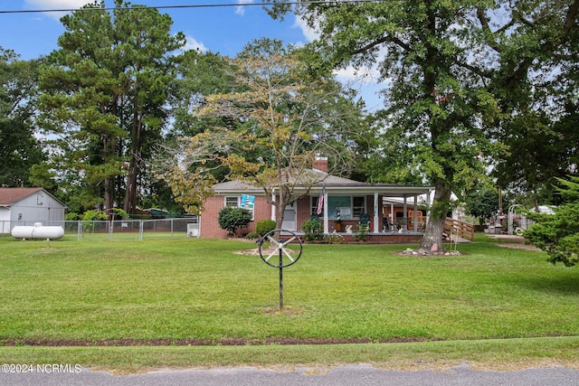 view of front of home with a front yard, a porch, and a storage shed