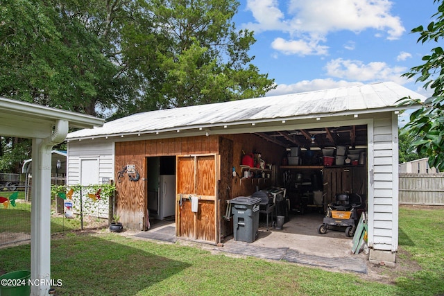 rear view of property with a lawn and an outdoor structure