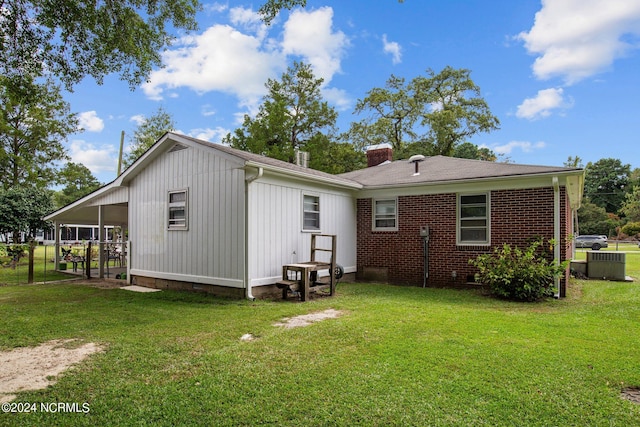 back of house featuring cooling unit and a yard