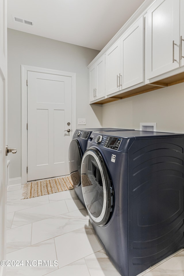 washroom with separate washer and dryer and cabinets