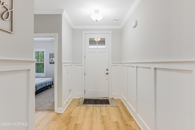 foyer entrance with crown molding and light wood-type flooring