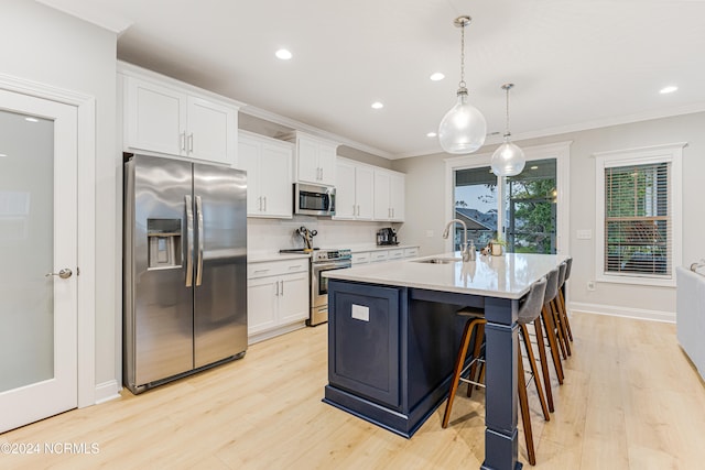 kitchen featuring white cabinetry, a kitchen island with sink, light hardwood / wood-style flooring, decorative light fixtures, and stainless steel appliances