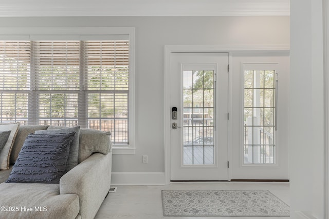 entryway featuring baseboards and crown molding