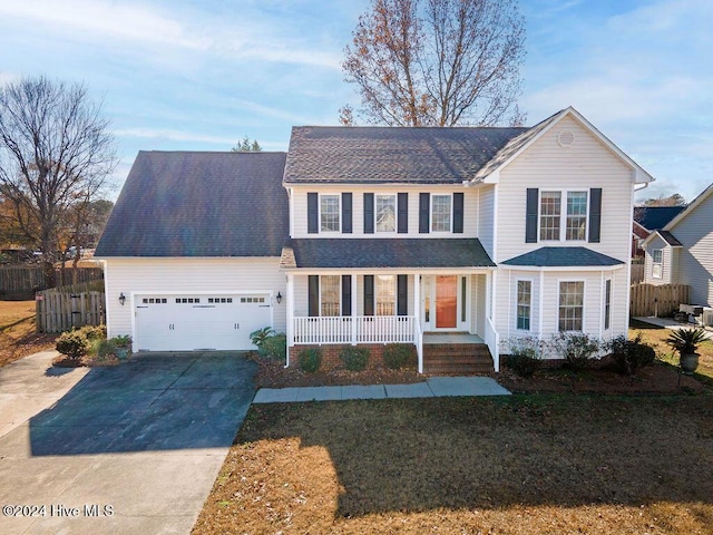 view of front of property featuring a porch, a front yard, and a garage