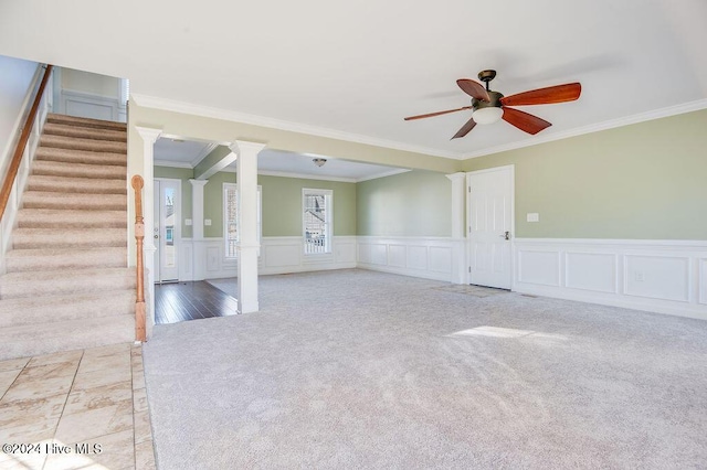 carpeted spare room with decorative columns, ceiling fan, and ornamental molding