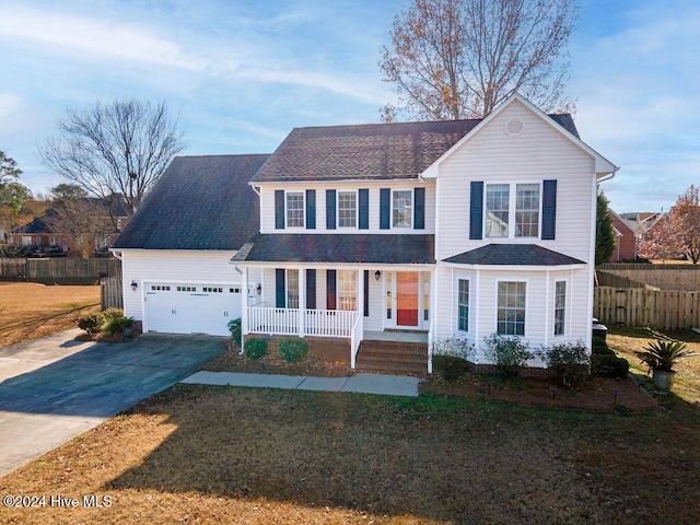 view of front of house with a front yard, a porch, and a garage