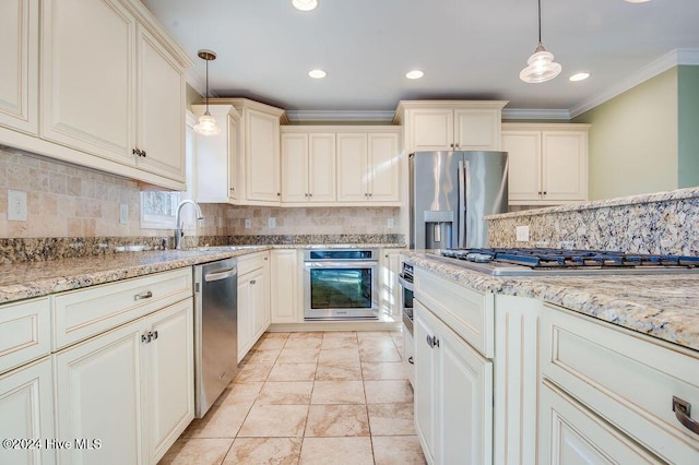 kitchen featuring cream cabinetry, appliances with stainless steel finishes, and pendant lighting