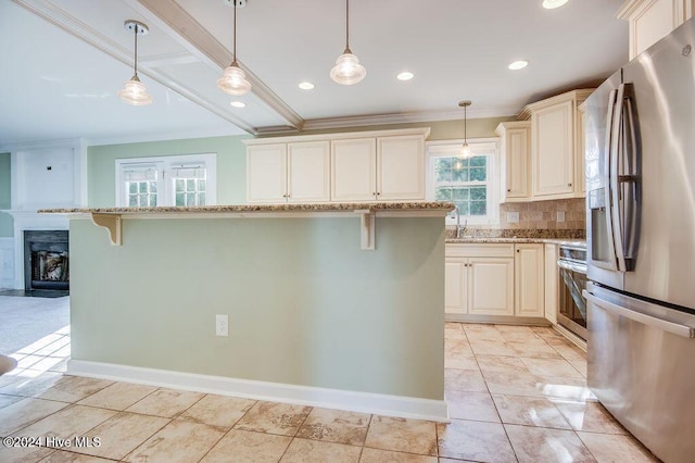 kitchen with cream cabinetry, stainless steel fridge with ice dispenser, a kitchen island, and range