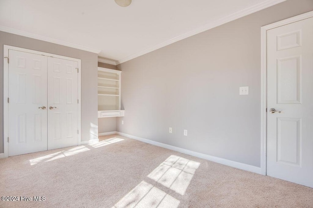 unfurnished bedroom with carpet flooring, a closet, and crown molding