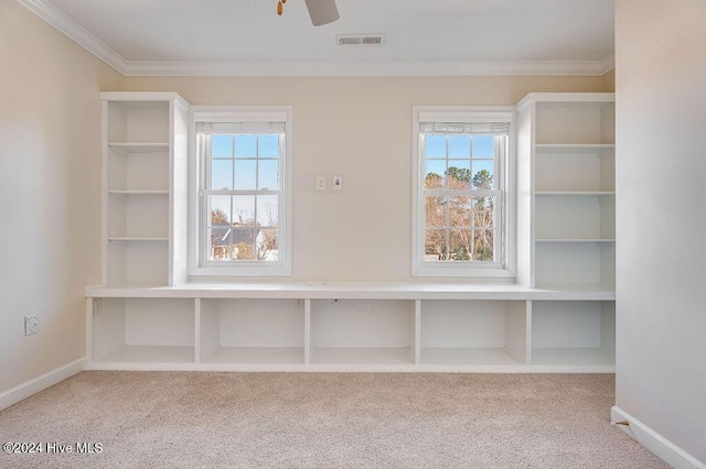 interior space with carpet, a wealth of natural light, ornamental molding, and ceiling fan