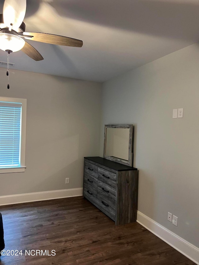 unfurnished bedroom with ceiling fan and dark hardwood / wood-style floors