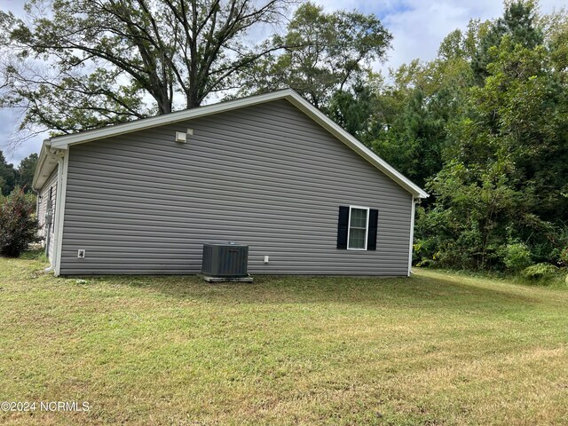 view of property exterior with a lawn and central air condition unit