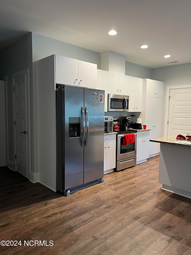 kitchen featuring appliances with stainless steel finishes, wood-type flooring, and white cabinetry