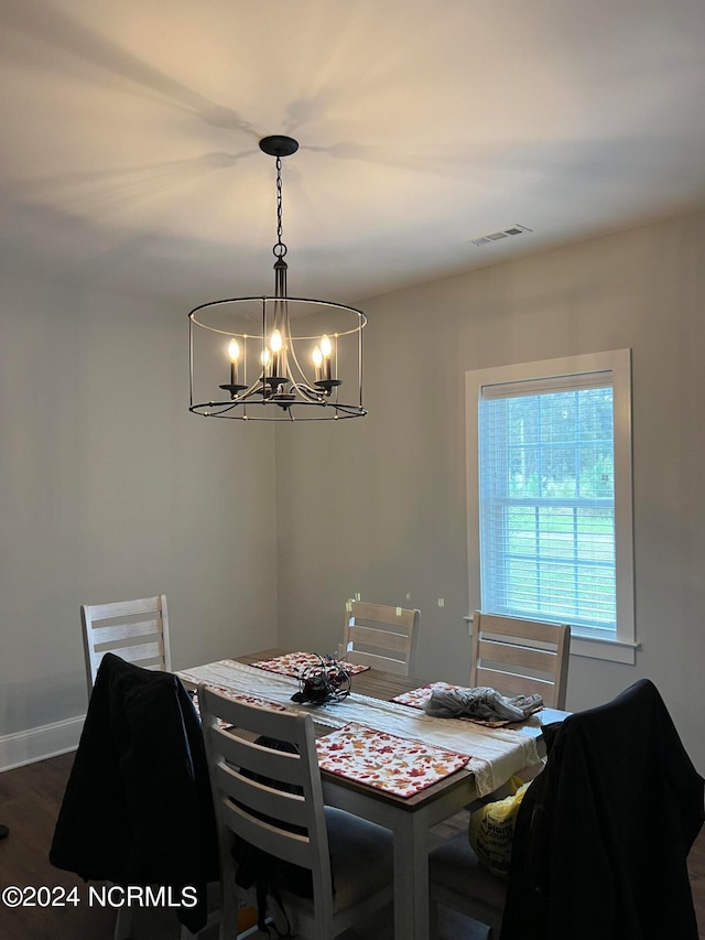 dining area featuring dark hardwood / wood-style floors and a chandelier