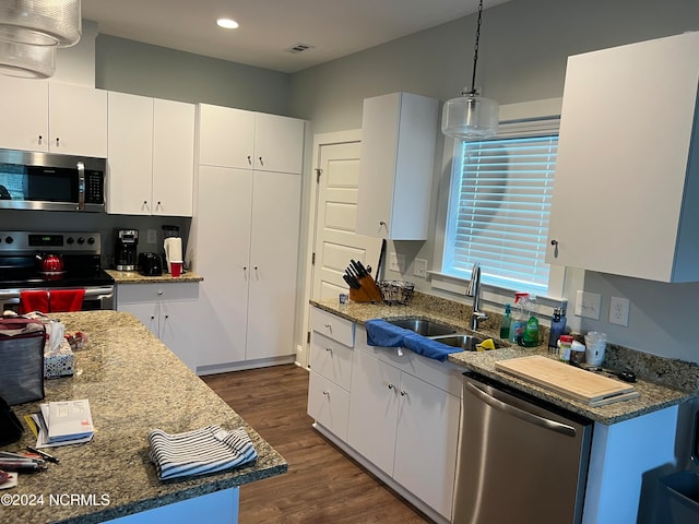 kitchen with pendant lighting, white cabinetry, appliances with stainless steel finishes, and dark hardwood / wood-style flooring