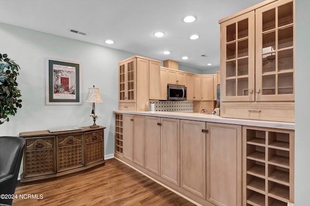 kitchen with light wood-type flooring, tasteful backsplash, sink, and light brown cabinets