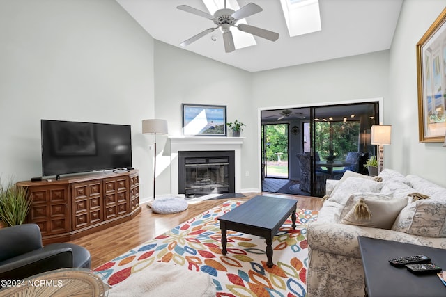 living room with high vaulted ceiling, ceiling fan, and wood-type flooring