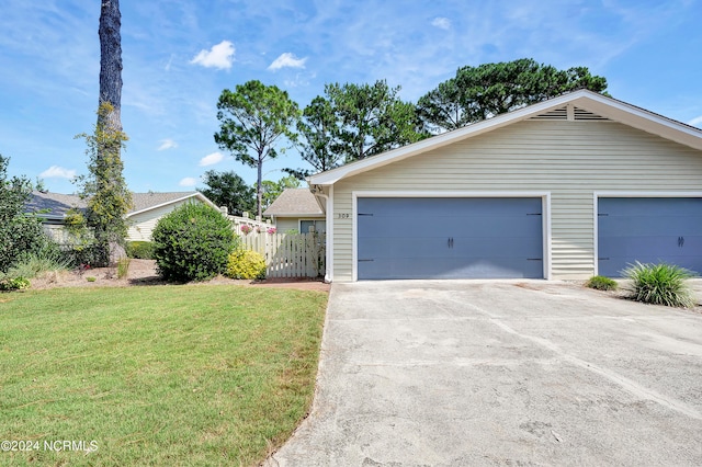 single story home with a garage and a front lawn