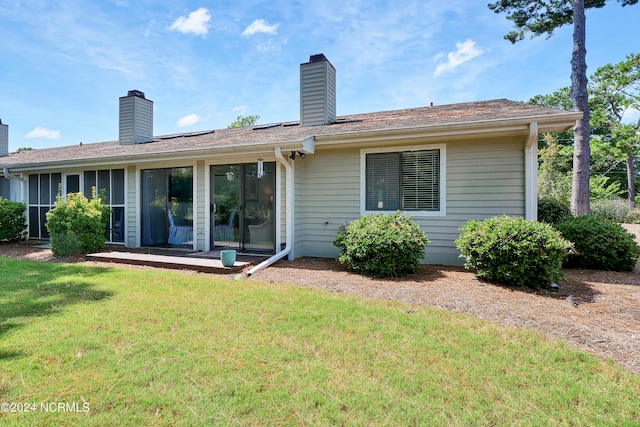 rear view of property featuring a yard