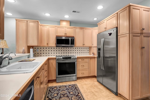 kitchen featuring stainless steel appliances, sink, backsplash, and light brown cabinetry