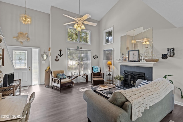 living room with wood-type flooring, plenty of natural light, high vaulted ceiling, and a tile fireplace