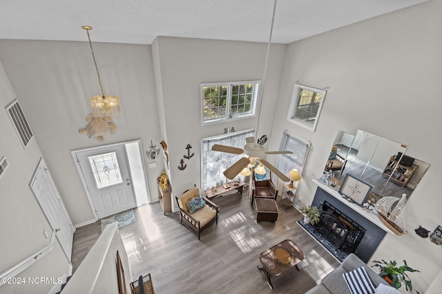 living room featuring ceiling fan with notable chandelier, hardwood / wood-style floors, and high vaulted ceiling