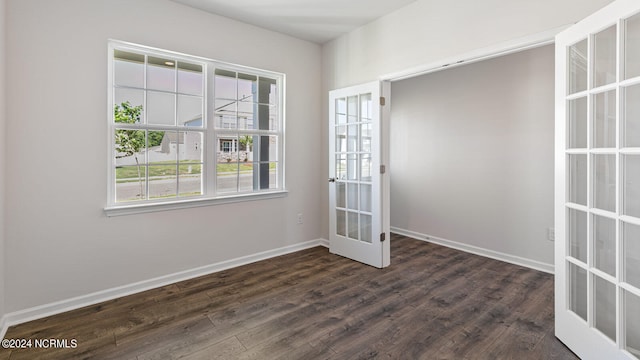 spare room with dark hardwood / wood-style flooring and french doors