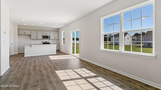 kitchen featuring gray cabinets, dark hardwood / wood-style flooring, a kitchen island, and electric stove