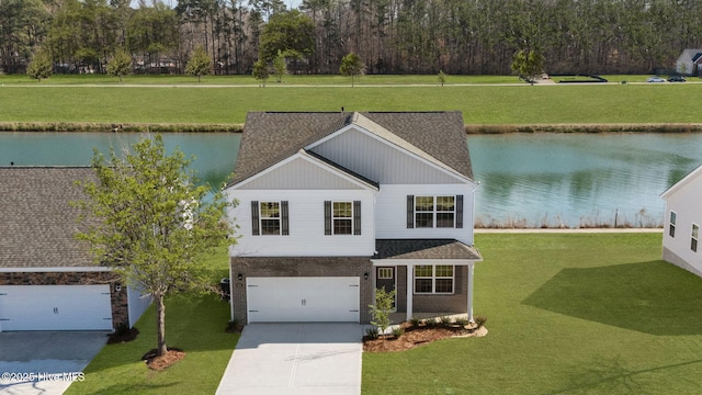 view of front of house with a water view, driveway, and a shingled roof