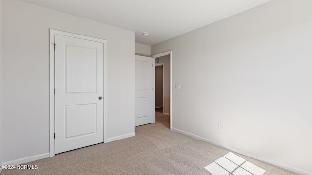 unfurnished bedroom featuring light carpet