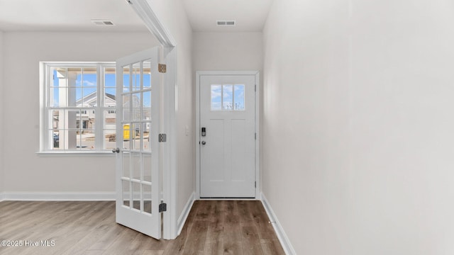 doorway featuring visible vents, plenty of natural light, and wood finished floors