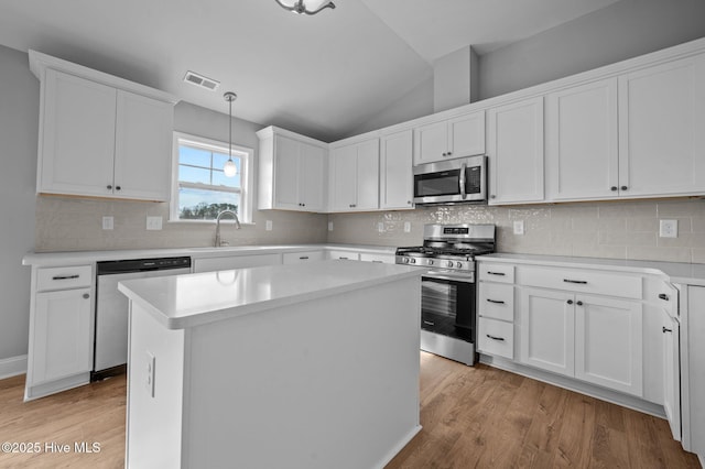 kitchen featuring white cabinetry, hanging light fixtures, a center island, sink, and appliances with stainless steel finishes