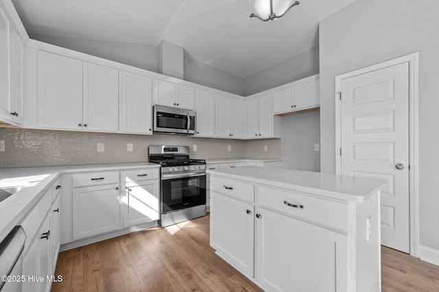 kitchen featuring white cabinetry, a kitchen island, stainless steel appliances, and light wood-type flooring