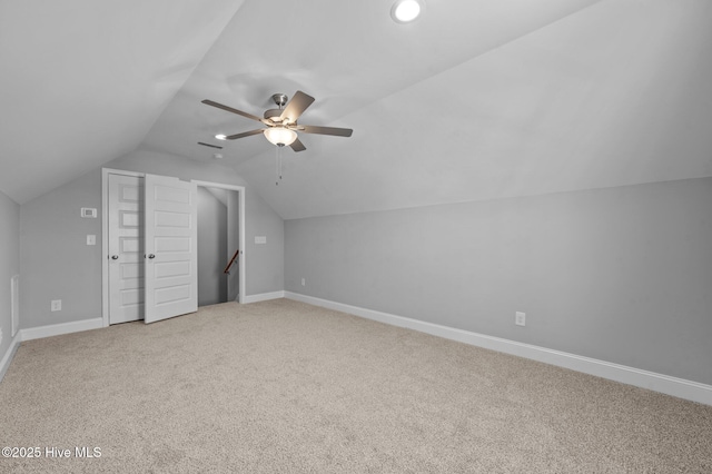 additional living space featuring vaulted ceiling, light colored carpet, and ceiling fan