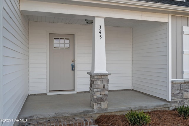 view of exterior entry featuring covered porch