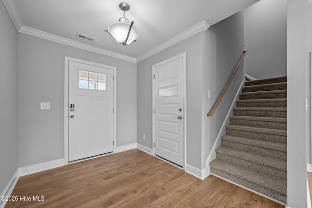 foyer entrance featuring ornamental molding and light hardwood / wood-style flooring