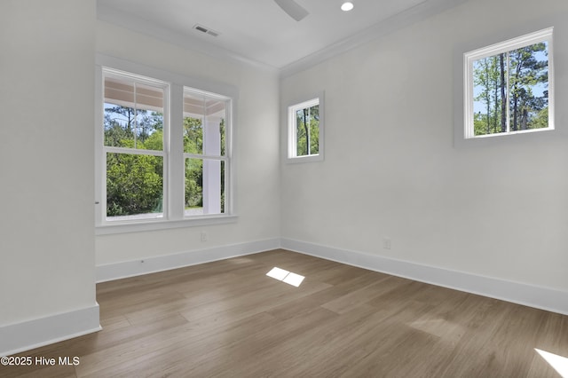 empty room with ceiling fan, baseboards, wood finished floors, and visible vents