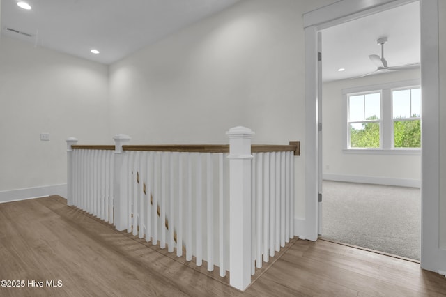 corridor with wood finished floors, an upstairs landing, baseboards, visible vents, and recessed lighting