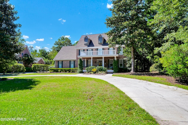 view of front of property with a balcony and a front lawn