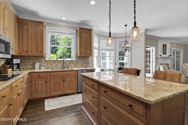 kitchen featuring a notable chandelier, stainless steel appliances, a kitchen island, sink, and dark wood-type flooring