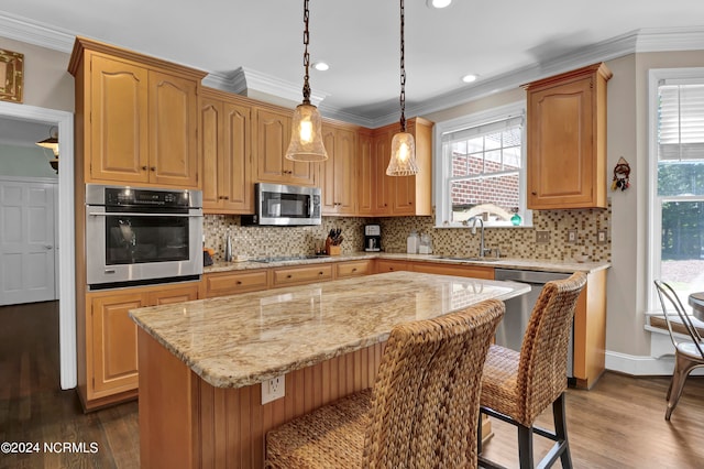 kitchen featuring a wealth of natural light, a center island, sink, and appliances with stainless steel finishes