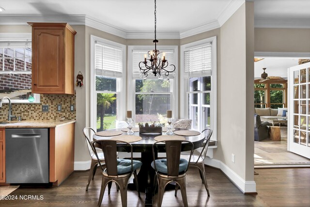 dining room featuring ceiling fan with notable chandelier, dark hardwood / wood-style flooring, crown molding, and sink