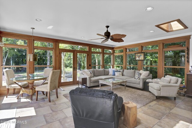 living room featuring ceiling fan, french doors, and a skylight